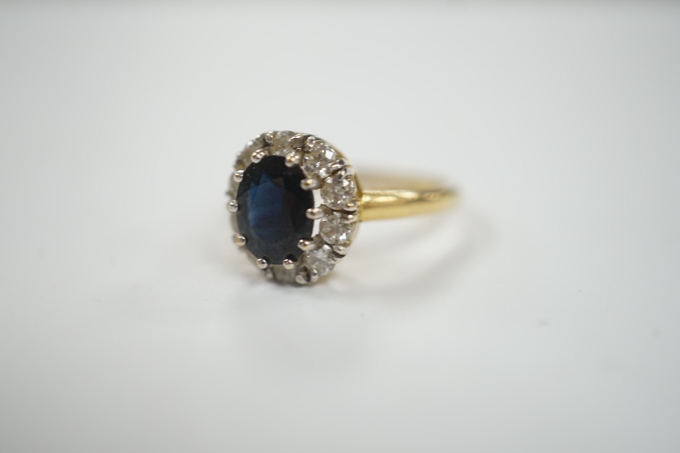 A modern 18ct gold, sapphire and diamond set oval cluster ring, size L, gross weight 3.8 grams.